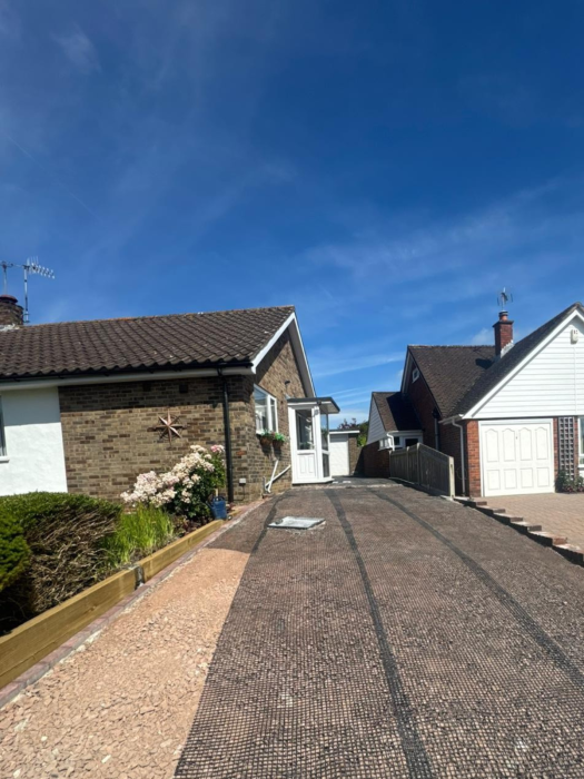 New driveway sub-base preparation with brick edging and sleeper retaining border.